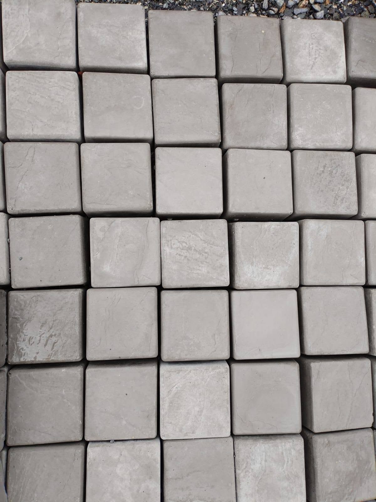 Square concrete pavers laid out in a grid